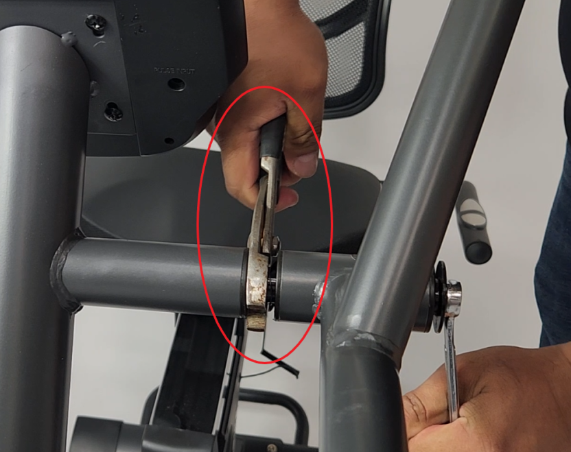 A person using a tool to fix a exercise bike

Description automatically generated
