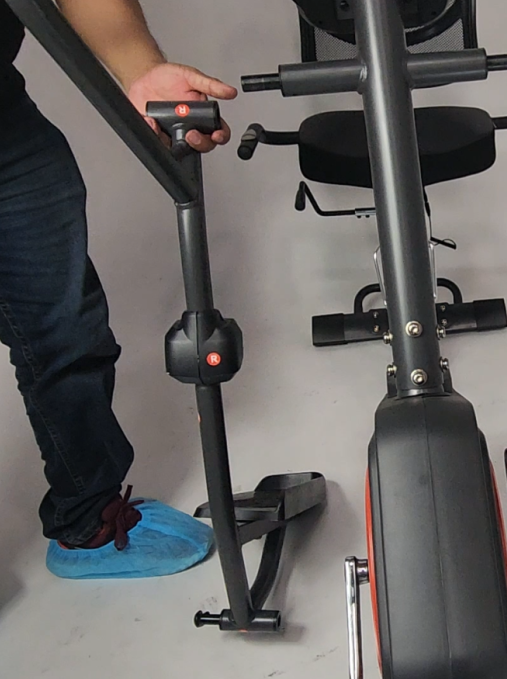 A person holding a exercise bike

Description automatically generated